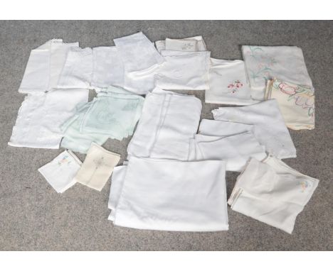 A group of vintage linens. To include tablecloths and napkins. Some are embroidered with flowers and others are plain.  