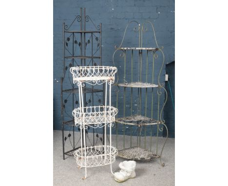 A collection of garden items. Includes folding shelving units, metal planter stand and a concrete boot.  