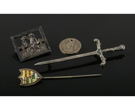 A small collection of silver jewellery. Includes Eneret brooch, sword brooch, enamel stick pin and a three pence coin.  