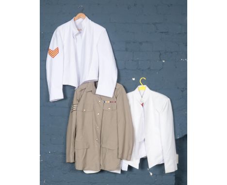 A collection of army uniform. In white and khaki, with stripes and badges.  