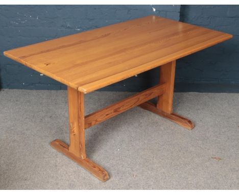 A Ercol pine refectory dining table. (73cm height, 81cm width, 142cm length) comes with pine effect protective cover.  