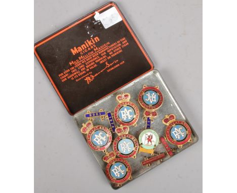 A Manikin cigar tin with contents of enamel motoring badges. Includes RAC Rally Of Great Britain, The International Welsh Ral