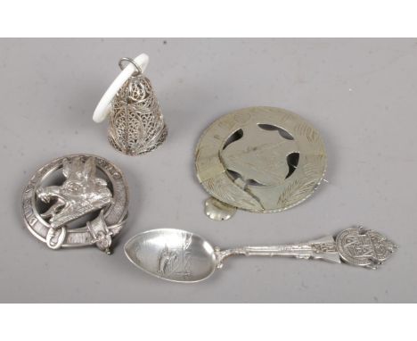 A collection of silver and white metal items. Includes silver spoon, filigree bell, hunting badge etc.  