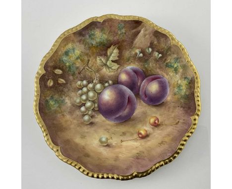 P English for Royal Worcester, a fruit painted plate, decorated with plums and grapes, within a gilt gadrooned border, black 
