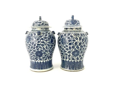 A lage pair of Chinese blue and white temple jars and covers, inverse baluster form, painted with foliate scroll and lotus fl