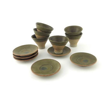 Robin Welch, a set of six studio pottery tea or soup bowls and saucers, conical form on cylindrical feet, green banded glaze,