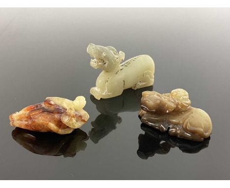 Three Chinese hardstone carvings, including a jade dragon, a man holding a bullock, and a monkey, 6.5cm (3)