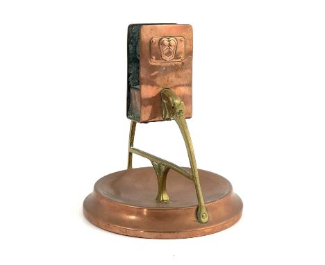 WMF, a Jugendstil copper and brass matchbox holder, the rectangular holder supported on two arched elephant head arms united 