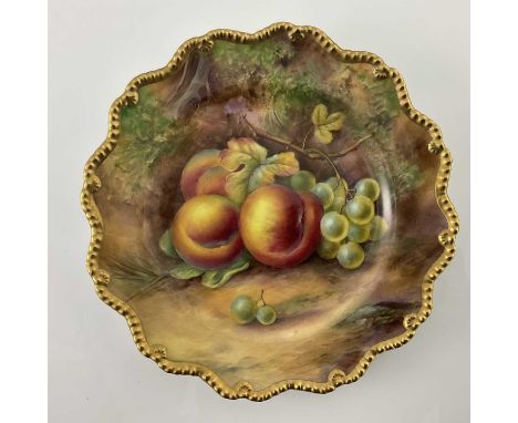 H Price for Royal Worcester, a fruit painted plate, decorated with peaches and grapes, within a gilt gadrooned border, black 