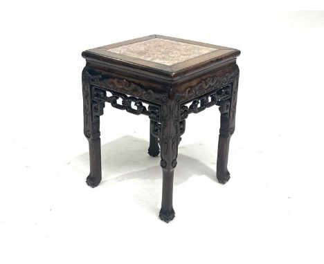 A Chinese hardwood low table, early 20th Century, square section with inset pink marble top, scroll carved and fretwork friez