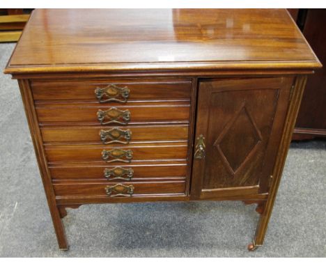 A mahogany music cabinet, moulded top, six drawers, adjacent cupboard, fluted square legs, ceramic casters, circa 1900.