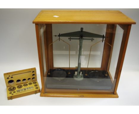 A set of scientific balance scales, cased with cased weights.
