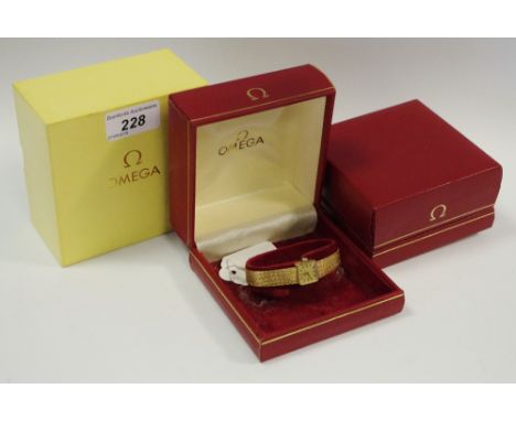 A 9ct gold lady's Omega watch, manual movement, integral strap, boxed, gross weight 22g, an empty Omega box. 