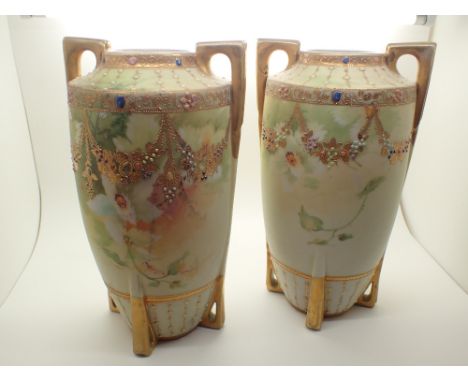 Pair of twin handled four footed Noritake vases with jewel and gilt decoration  CONDITION REPORT: One vase has a slight hairl