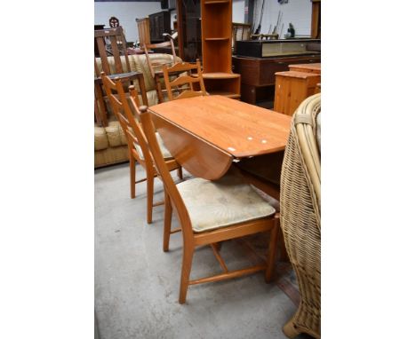 A modern mid century designed dining set by Ercol four ladder back chairs and matching circular table