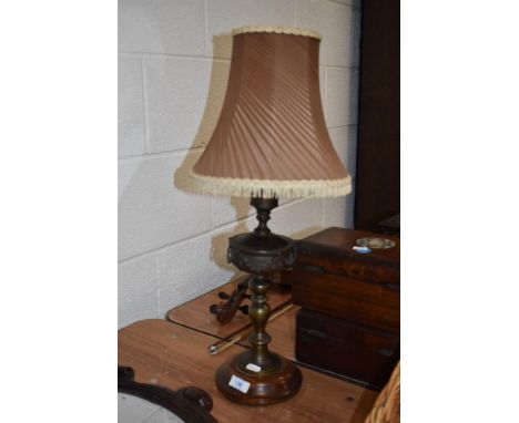 An early 20th century brass table lamp, having swag decoration and knopped stem, sat on wooden base.
unwired.