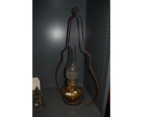 A vintage brass stable lamp with bracket, having glass chimney.