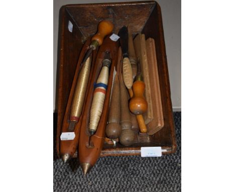 A vintage wooden trug housing a selection of bobbin shuttles, peggy rug making tools and crochet hooks etc.