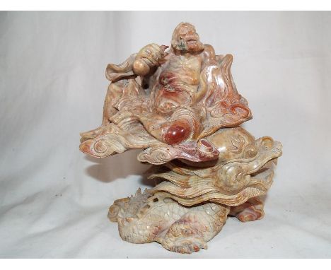 A good quality Chinese soapstone fine carved statue depicting a man riding a lucky dragon 23 cm (h) Estimate £100 - £200