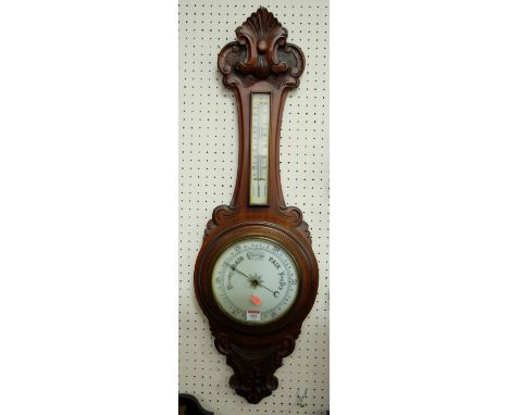 An early 20th century carved walnut two dial aneroid wheel barometer