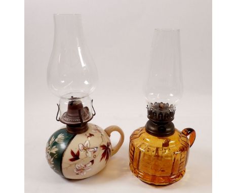 An opaque floral glass finger lamp and an orange glass one 