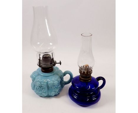 An opaque floral glass finger lamp and a blue glass one 