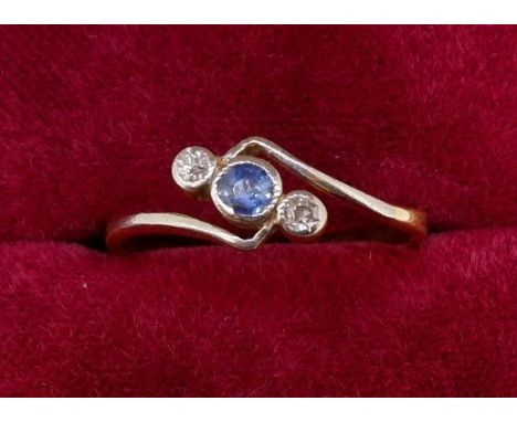 A 9 carat gold crossover ring set blue stone flanked by two diamonds, size P 2.5g 