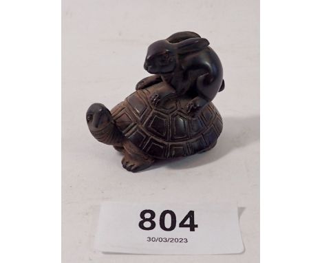 A Japanese carved hardwood netsuke with hare riding a tortoise 