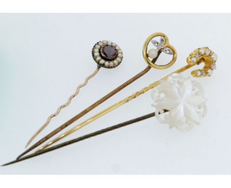 An Edwardian gold horseshoe stick pin set seed pearls and diamonds (unmarked) two other antique yellow metal stick pins and a