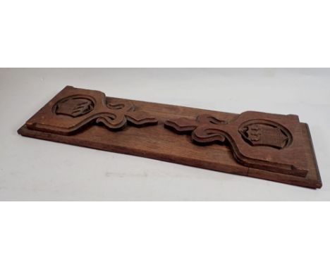 A carved oak extending book shelf with shield and bird design ends fully extended 69cm long