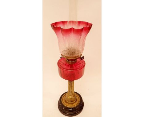 A Victorian brass oil lamp on black base and with frilled and etched cranberry glass shade, 67cm