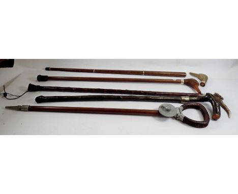 A shooting stick, two brass duck head walking sticks - one a/f and two other walking sticks 