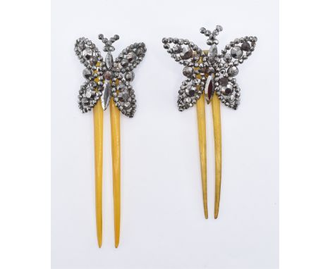 A pair of 19th Century Victorian hair combs having cut steel butterflies mounted on hinges to the tops of the two prong horn 