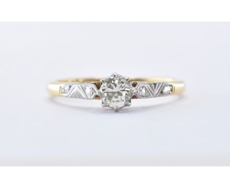 An Art Deco 18ct gold and platinum diamond ring being set with a round cut diamond in a cathedral setting with engraved plati