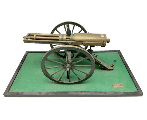 Scratch built brass model of an 1861 Gatling Gun with rotating barrels, hinged cover revealing mechanism, on metal bound wood