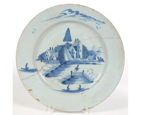 AN ENGLISH DELFTWARE DISH, PAINTED IN BLUE WITH A LANDSCAPE WITH FIGURES, INCLUDING AN ANGLER, 34CM D, C1770, BROKEN IN TWO A