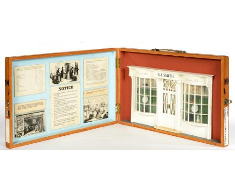 A WHITE PAINTED WOOD ARCHITECTURAL MODEL OF AN EARLY 19TH C SHOP FRONT, IN PAINTED WOOD TRAVELLING CASE, 38 X 61CM 