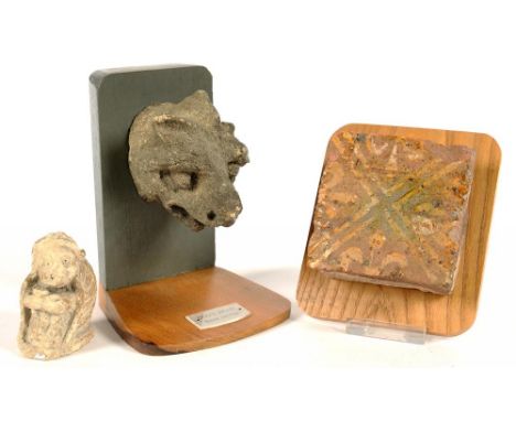 A MEDIEVAL ENGLISH ENCAUSTIC TILE, 10 X 10CM, 13TH / 14TH C, A MEDIEVAL CARVED STONE DONG'S HEAD, MOUNTED AND A MINIATURE STO