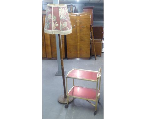 A TURNED WOOD STANDARD LAMP, ON CIRCULAR BASE AND THE FABRIC SHADE AND A GILT METAL TEA TROLLEY WITH TWO RED ANODISED REMOVAB