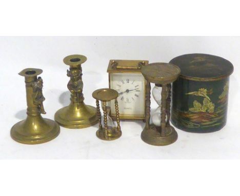 A PAIR OF BRAS PIXIE PATTERN CANDLESTICKS, A CIRCULAR BISCUIT TIN, TWO BRASS SAND TIMERS AND A QUARTZ CARRIAGE CLOCK 