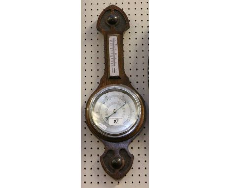 A carved oak wall mounting barometer and thermometer.