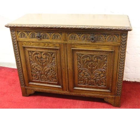 An extensively carved oak sideboard raised on bracket feet.