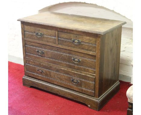 An Edwardian oak two over two chest of drawers raised on bracket feet.