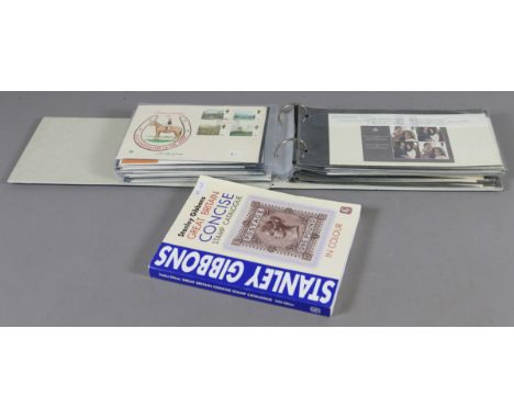 A stamp album containing sixty first day covers together with a GB stamp catalogue.