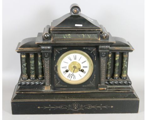 An ebonized mantel clock chiming on a coiled gong.
