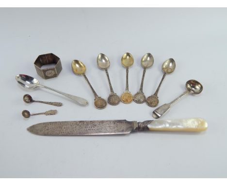 A Victorian silver bread knife with mother of pearl handle, Birmingham 1890, five teaspoons with golfing terminals, Birmingha