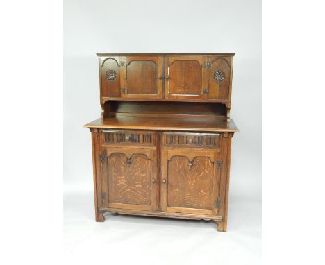 An oak court cupboard, with two doors above a pair of frieze drawers, cupboards below, raised on ogee bracket feet, 12.5cm x 