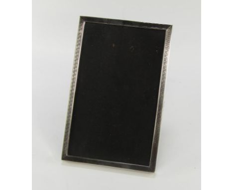 A George V silver rectangular photograph frame, decorated with an engine turned Greek key design, Birmingham 1920, aperture t