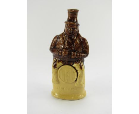 An early 19thC stoneware flask of Jim Crow, modelled seated on a barrel, two tone treacle glaze, 23.5cm high.