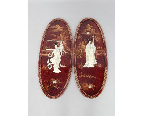 A pair of Chinese red lacquer oval plaques, overlaid in mother of pearl with a female warrior and a musician, 81cm x 35cm.
